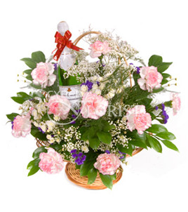 Inspiration. Subtle red and white carnations with baby&#39;s breath and greens are arranged in a round basket with a bottle of sparkling wine. A wonderful present for any holiday.
